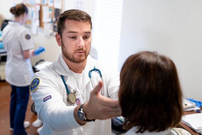 检查时，身穿白大褂的学生把手伸到病人的脸上.